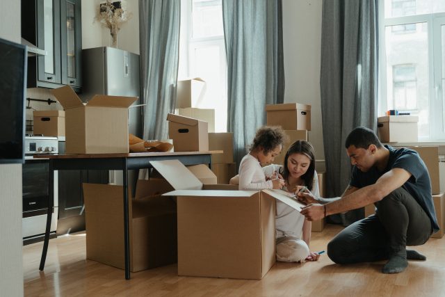 Couple at home packing moving boxes
