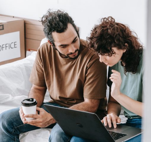 Couple on laptop with moving boxes