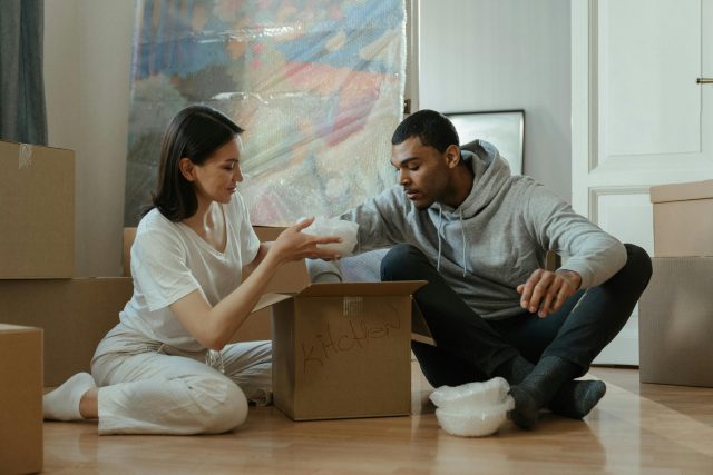 Mixed race couple packing up boxes to move home