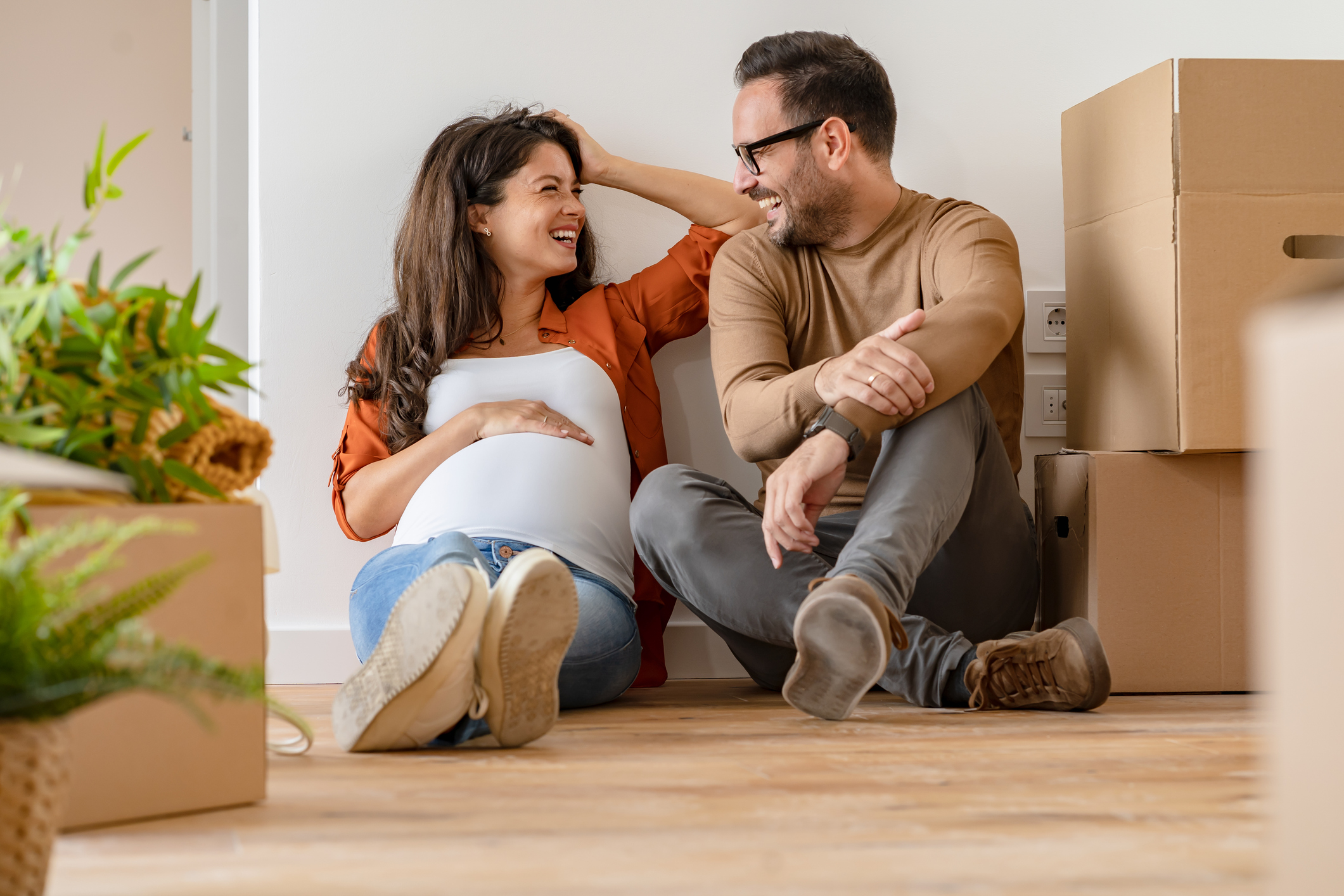 Young couple in new home surrounded by moving boxes